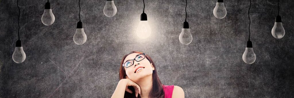 Portrait of smart female college student with books and bright light bulb above her head as a symbol of bright ideas