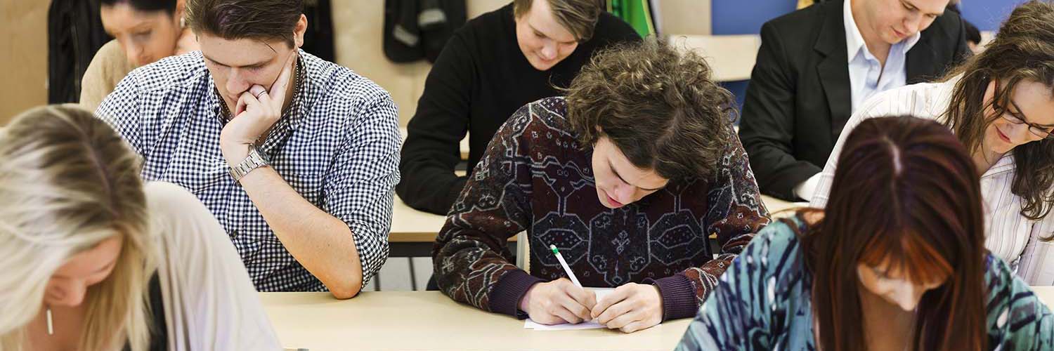Large group of young adults studying in a classroom