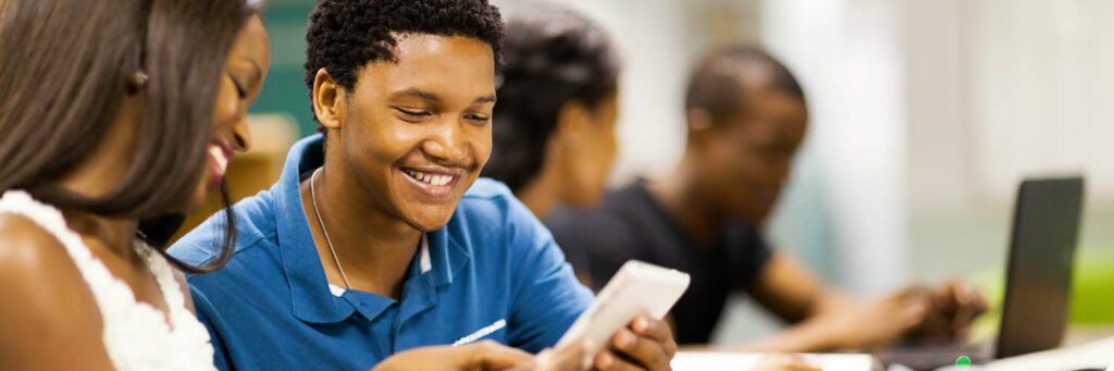 happy african college students using tablet computer together