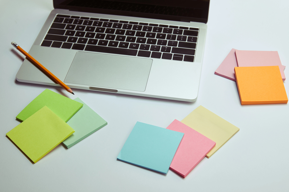 Open laptop with several post-it note pads