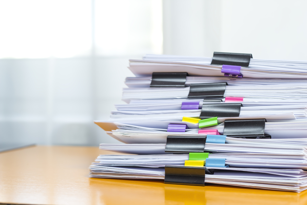 Stack of papers with different colored binder clips