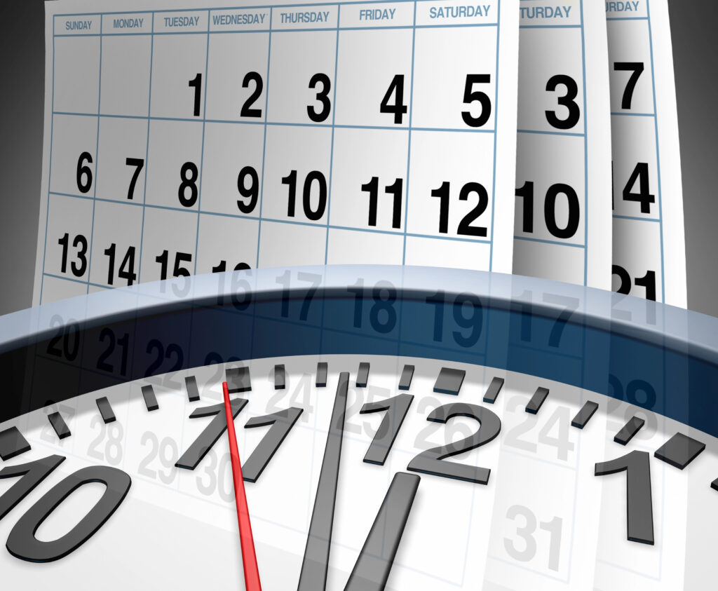 Clock face in front of a calendar page.